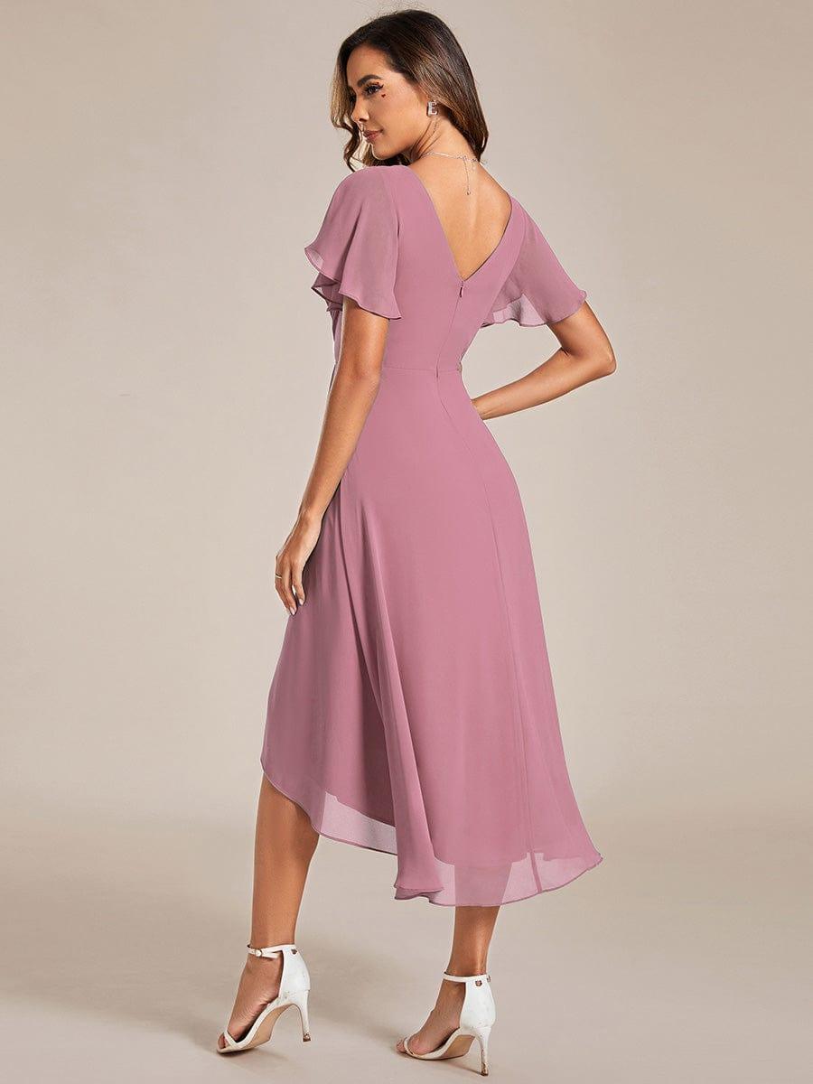 Back view of the mauve-pink dress, showing the V-shaped back with zip, flutter sleeves and the sloping high-low hemline. 59