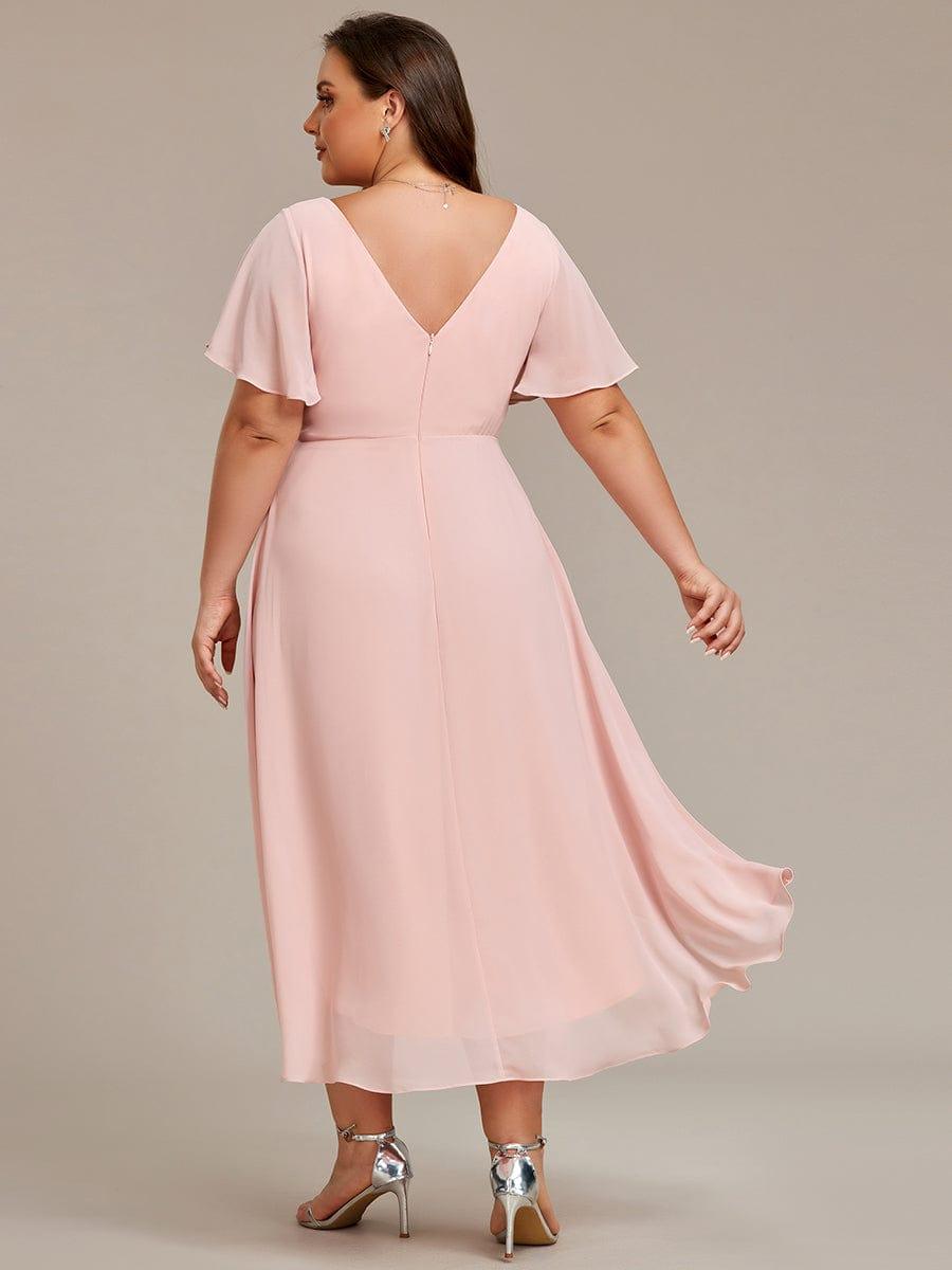 Back view of the pink dress on a plus-size model, showing the V back, zip and trailing chiffon hem. 32