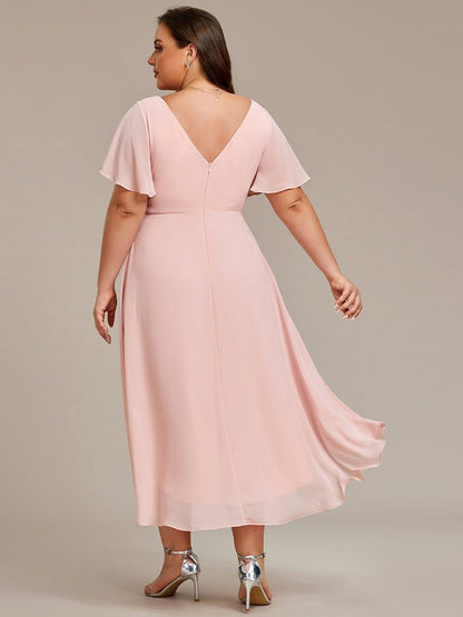 Back view of the pink dress on a plus-size model, showing the V back, zip and trailing chiffon hem. 32