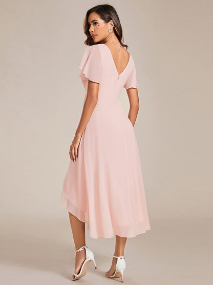 Back view of the pink dress, showing the V-shaped back opening, zip and layered high-low chiffon hem. 16