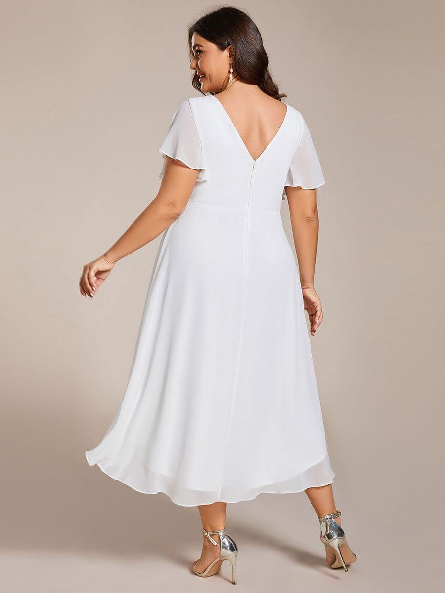 Back view of the white dress on a plus-size model, showing the V-back, zip and layered chiffon hem. 74