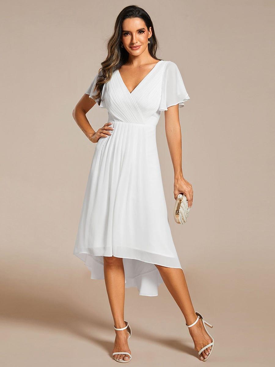White high-low chiffon dress worn by a model with one hand on hip, holding a pearl clutch, full-length front view. 71