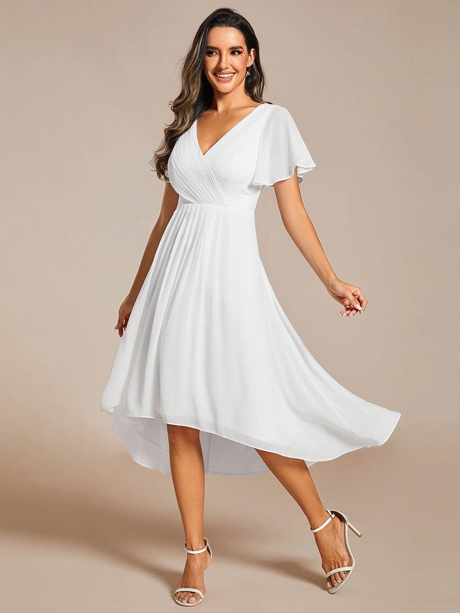 Model twirling in the white chiffon dress, skirt flaring out to show the high-low hem and white strappy heels. 72
