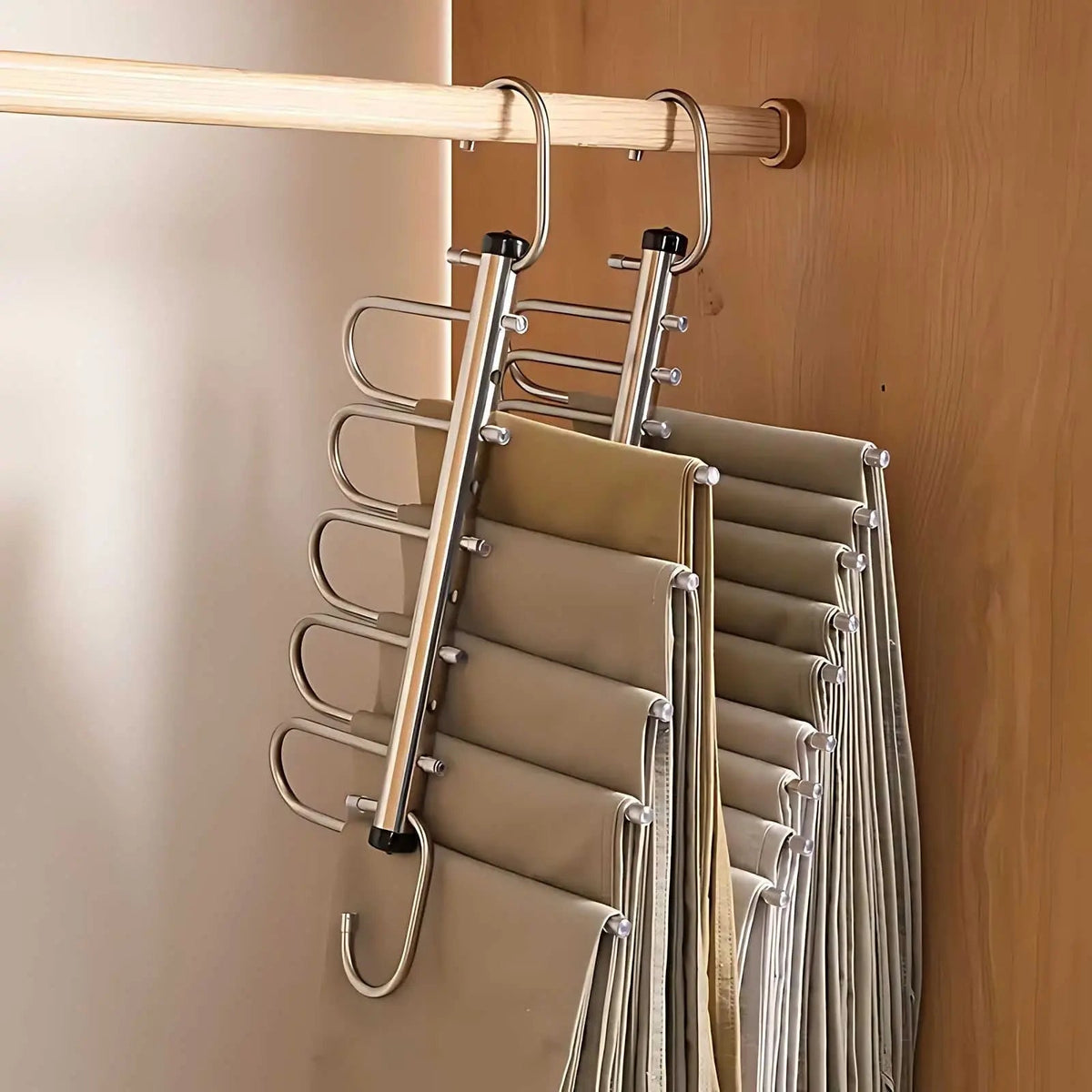 Side view of two tiered silver hangers on a wooden rail, with trousers draped over each of the stacked bars. 4