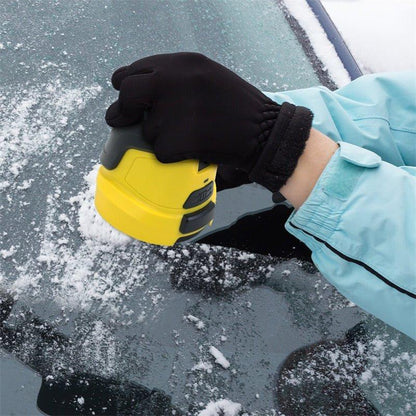 Hand in a black glove pressing the yellow scraper onto a snow-dusted car window 4