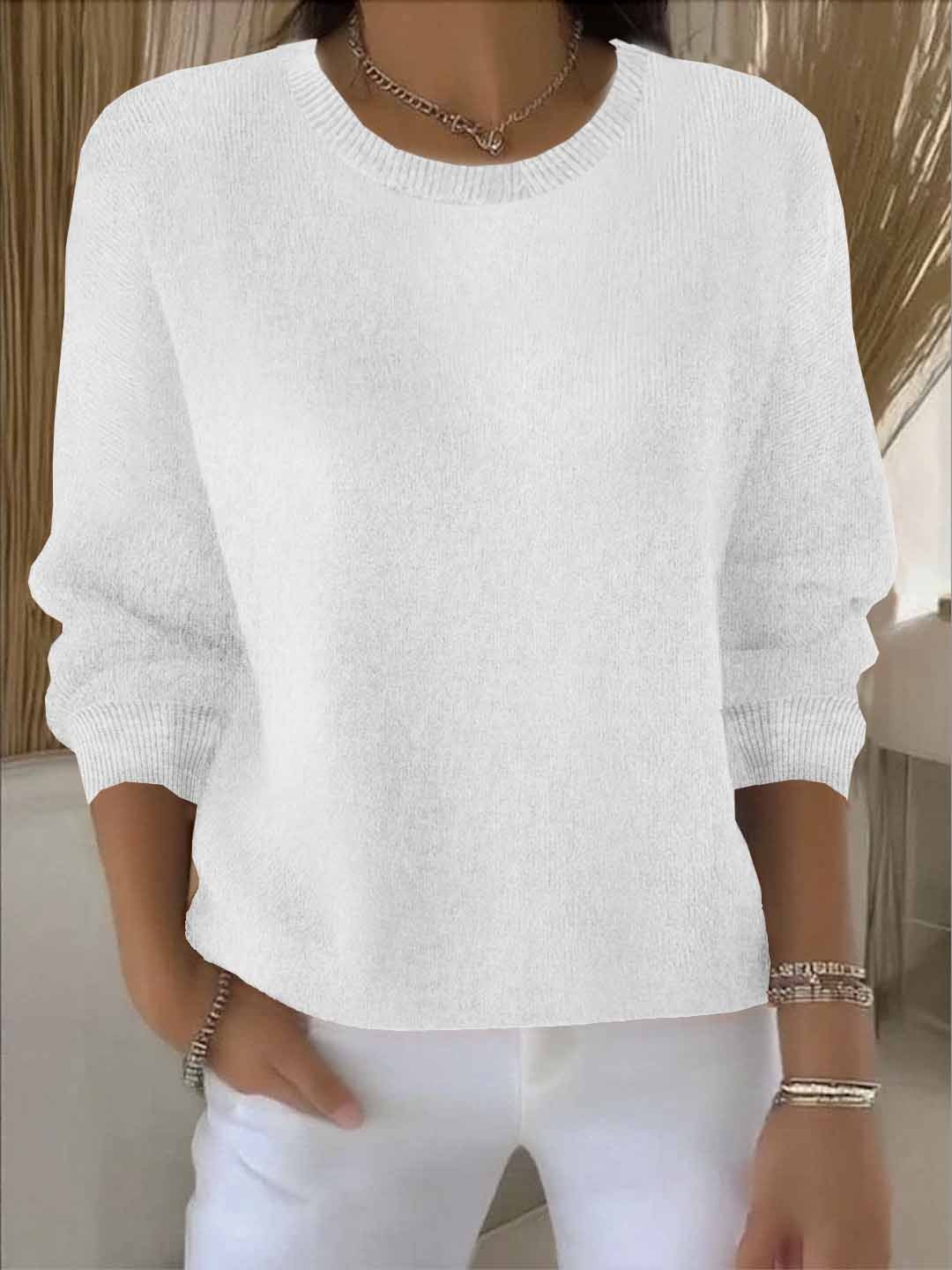 Model wears the round-neck knit jumper in white with white trousers, bracelets and a chain necklace 3