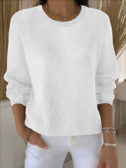 Model wears the round-neck knit jumper in white with white trousers, bracelets and a chain necklace 3