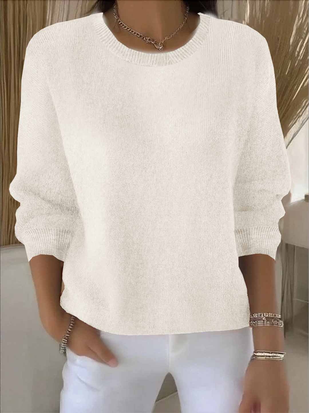 Model wears the round-neck knit jumper in cream with white trousers, bracelets and a chain necklace 4