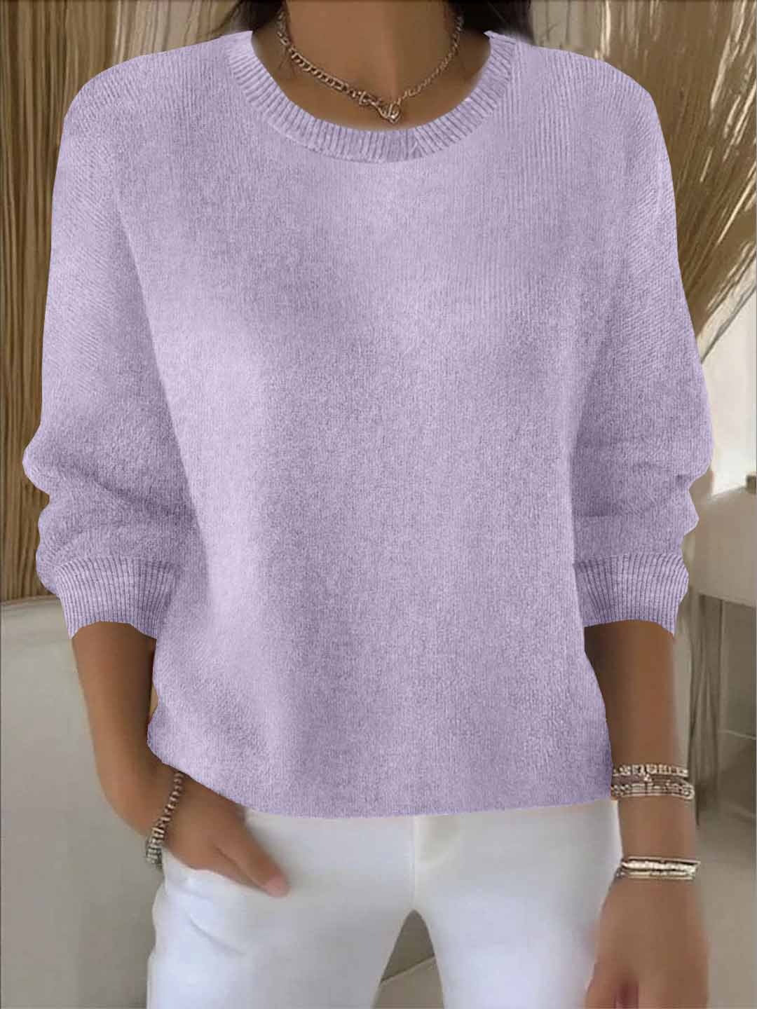 Model wears the round-neck knit jumper in lilac with white trousers, bracelets and a chain necklace 14
