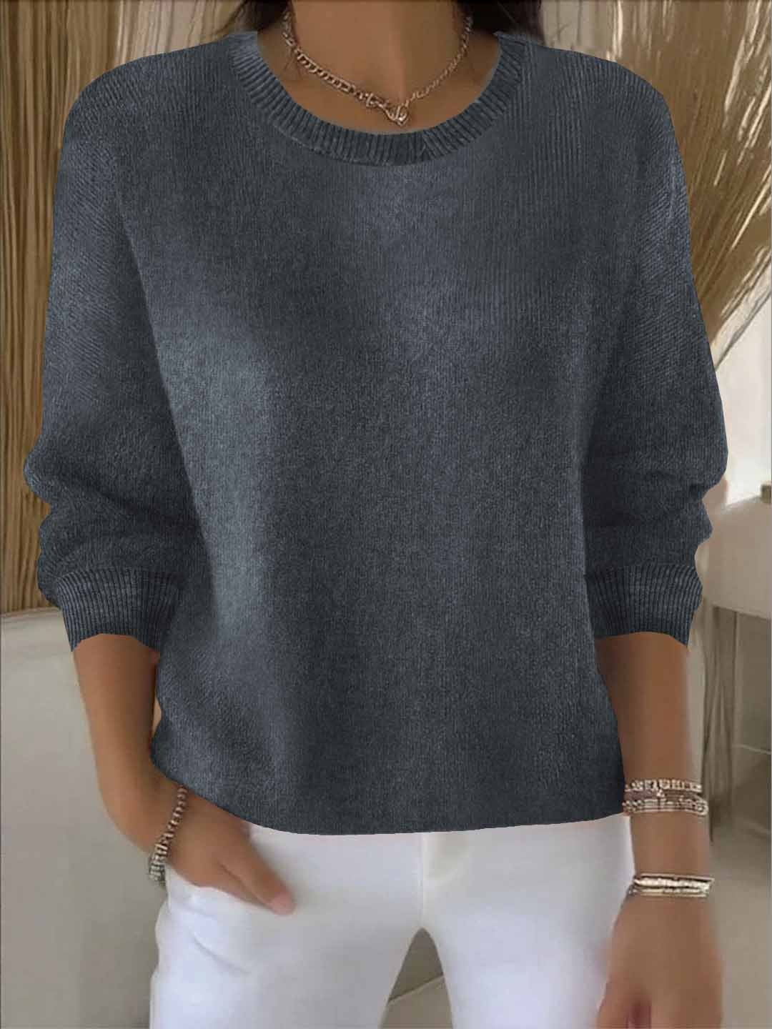 Model wears the round-neck knit jumper in slate grey with white trousers, bracelets and a chain necklace 6