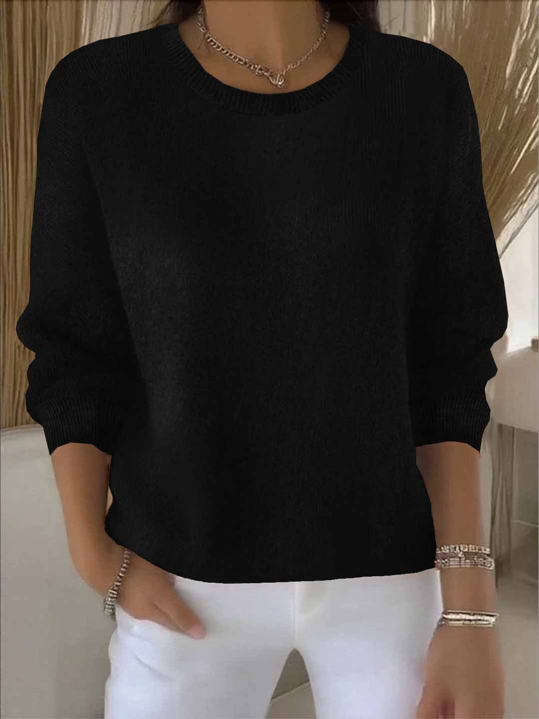 Model wears the round-neck knit jumper in black with white trousers, bracelets and a chain necklace 7