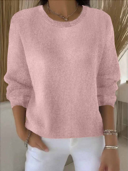 Model wears the round-neck knit jumper in soft pink with white trousers, bracelets and a chain necklace 2