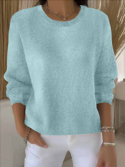 Model wears the round-neck knit jumper in pale aqua with white trousers, bracelets and a chain necklace 10