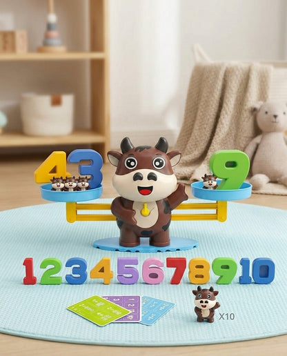 Brown cow balance with raised hand, rainbow numbers 1 to 10, three activity cards and a spare cow figure 8