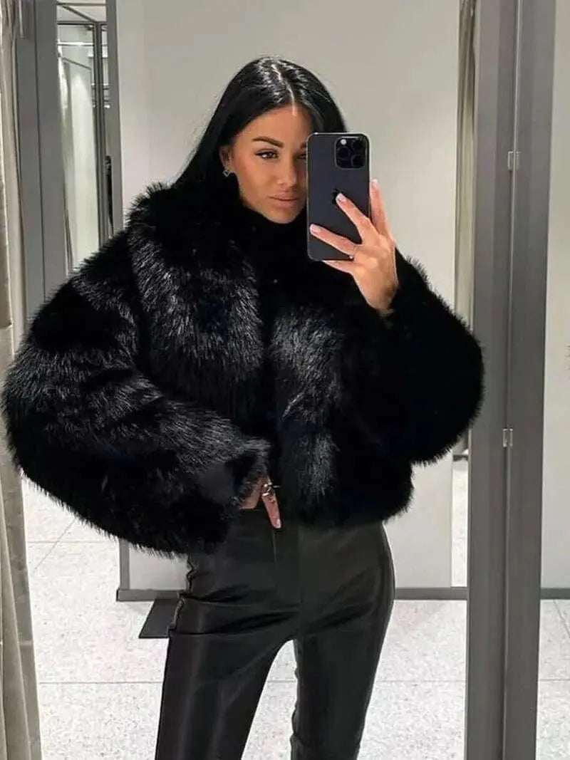 Woman taking a mirror selfie in the voluminous black faux fur coat and leather trousers 11