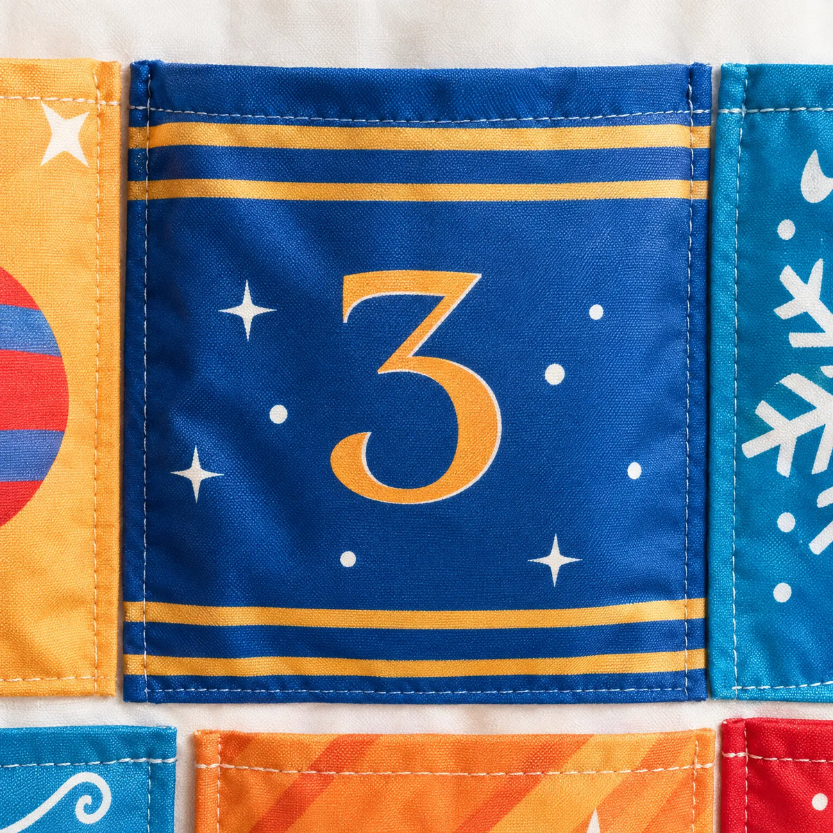 Close-up of the number 3 pocket in blue with gold stripes and stars, showing neat stitched edges and the fabric texture. 4