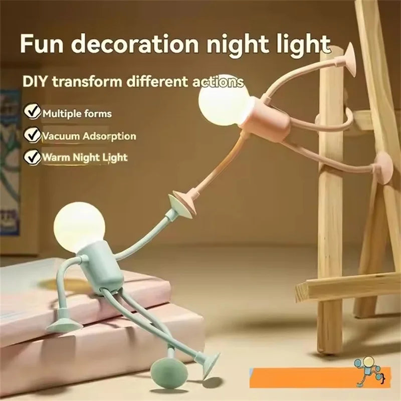 Pink figure light pushing against a wooden easel while a green one sits on books 4