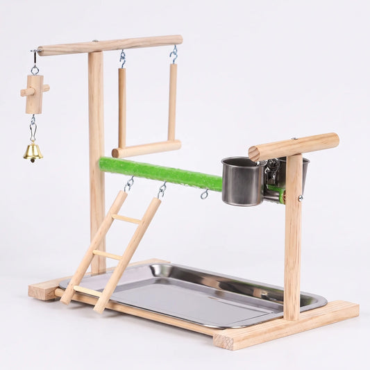 Wooden bird play stand on a plain background, with green sanded perch, ladder, swing, bell, two steel cups and a steel tray. 1