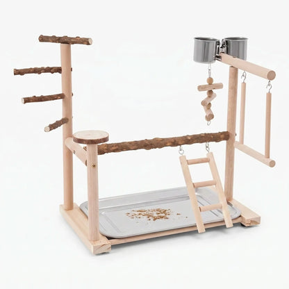 Wooden bird playground on a plain white background, with natural branch perches, a ladder, swings, hanging toy, two steel cups and a seed tray. 1