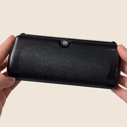 Back of the black brush held in two hands, showing the textured non-slip grip panel and the screw at the top. 3