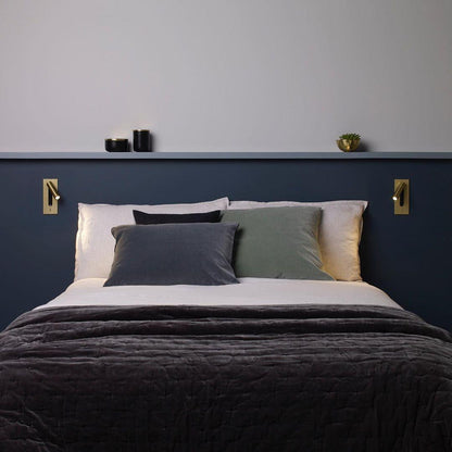 Pair of gold wall lights either side of a bed on a navy headboard 35