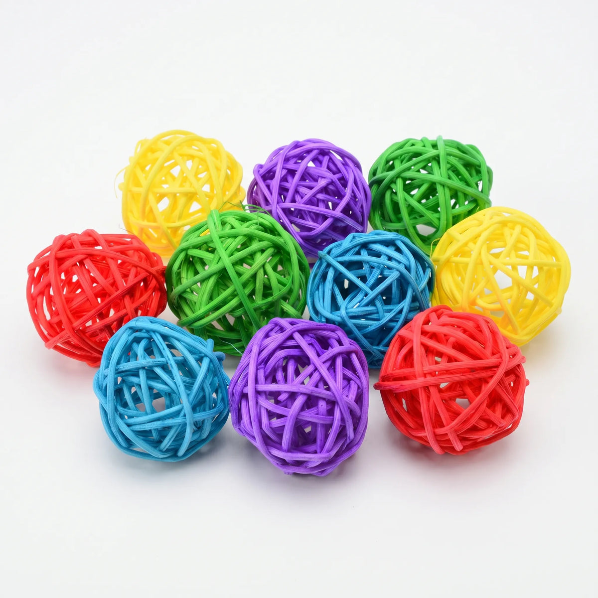 Ten woven rattan balls in red, yellow, green, blue and purple, piled together on a plain white background. 1