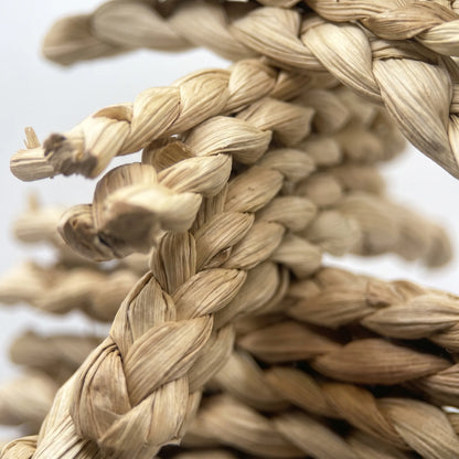 Close-up of the braided straw plaits, showing the twisted pale fibres and frayed ends that a bird can chew. 3