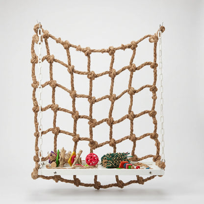 Rope climbing net hung on white plastic chains from hooks, with a white wooden platform holding colourful toys, against a plain background. 1