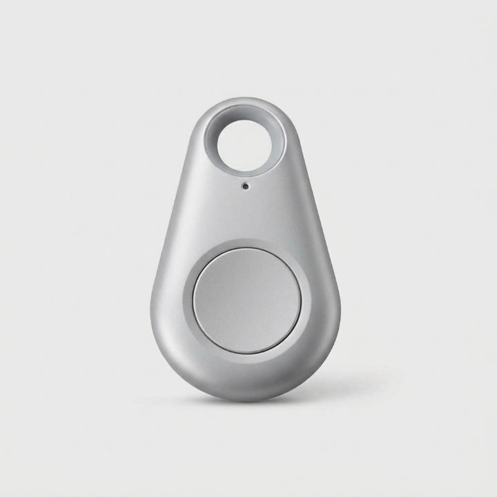 Silver-grey teardrop-shaped tracker with a round central button and keyring hole, on a plain background 10