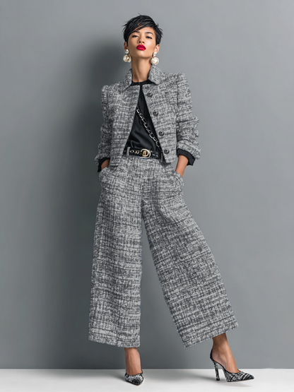 Model wearing the cropped textured jacket and wide-leg trousers in grey tweed, styled with a black top, belt and heels. 1