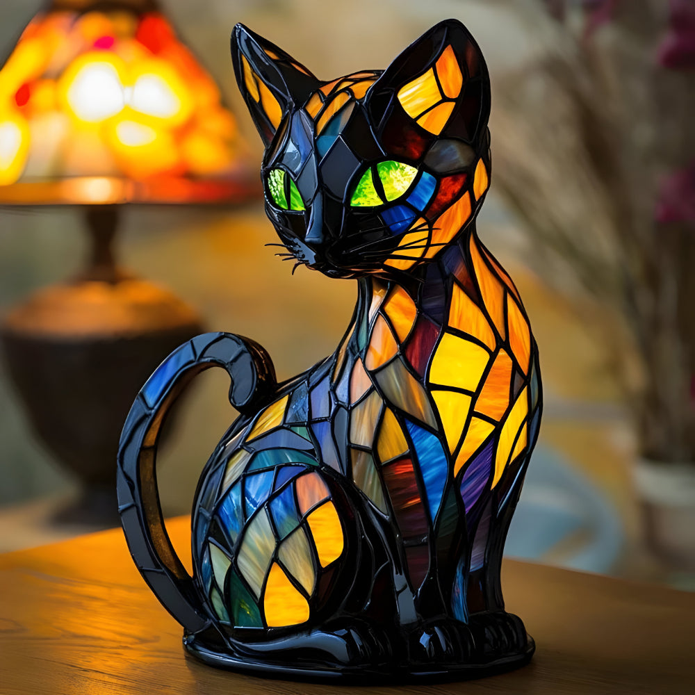 Seated black cat lamp with green eyes and amber, blue and purple mosaic panels, beside a glowing lamp 1