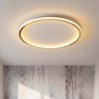 Gold ring ceiling light switched on, with a textured grey wall visible below 7