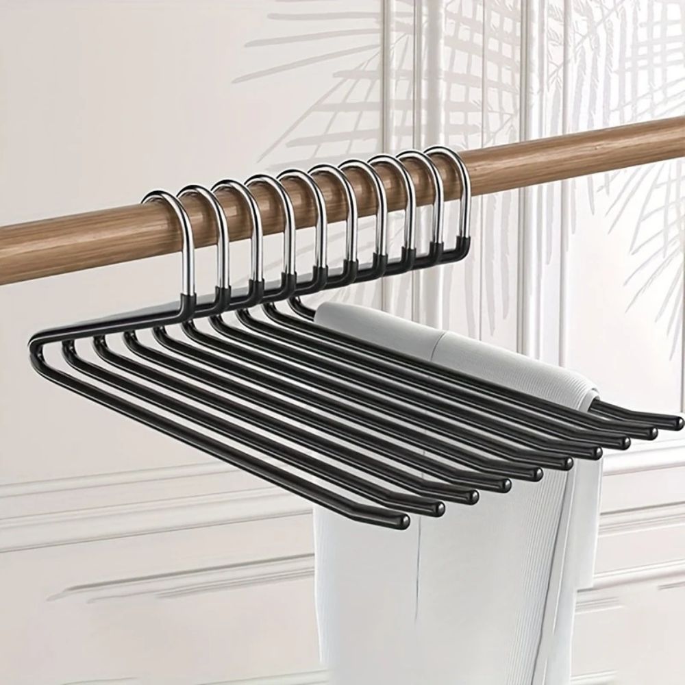 Row of black Z-shaped hangers on a wooden rail, holding a pair of white trousers 1