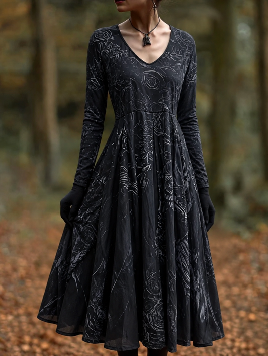 Model in a black V-neck dress with long sleeves, swirling grey rose pattern and flared skirt, worn with black gloves in an autumn wood. 1