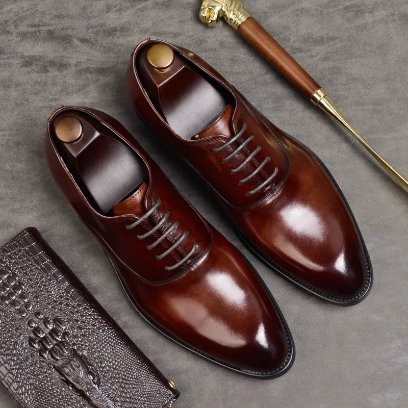 Flat lay of burgundy leather shoes with wooden shoe trees beside a golden-handled shoehorn and a croc-effect wallet 4