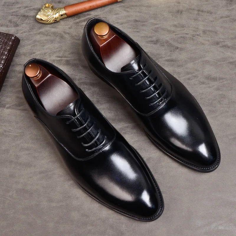 Flat lay of black polished leather lace-up shoes with wooden shoe trees on a textured grey surface 8