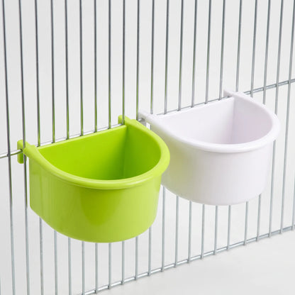 One green and one white half-round bowl hung on cage bars at an angle, shown together for colour comparison. 6