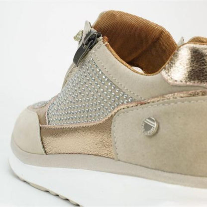 Close-up of the heel and side of a beige trainer, showing the zip, studded panel, gold metallic trim and tan lining. 9