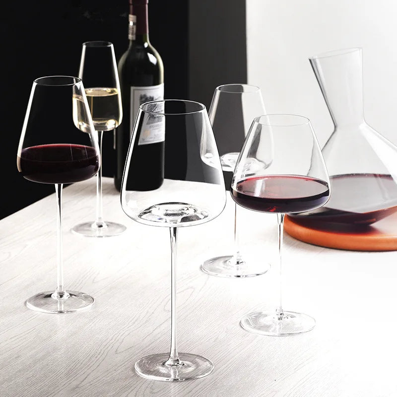 Set of red, white and sparkling wine glasses on a light wooden table beside a decanter 6