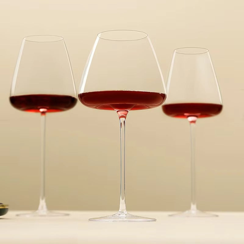 Three red wine glasses of different sizes lined up against a soft cream background 10