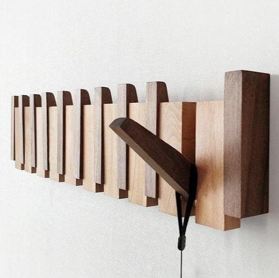 Close angled view of the two-tone wooden rack with one hook folded out on a black cord 7