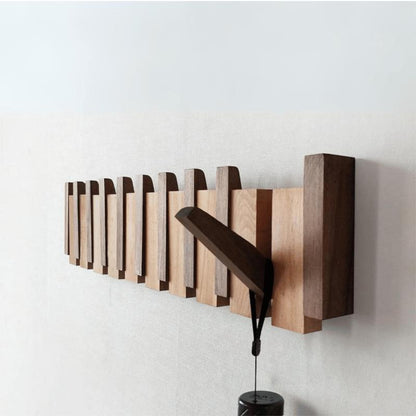 Angled side view of the wooden rack with a single hook swung out and a black item hanging 5
