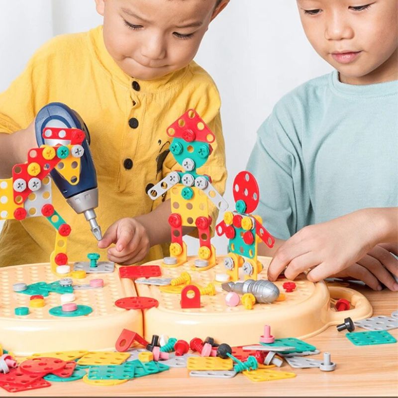 Two children build robot figures together on the open pegboard case, one holding the blue toy drill. 3