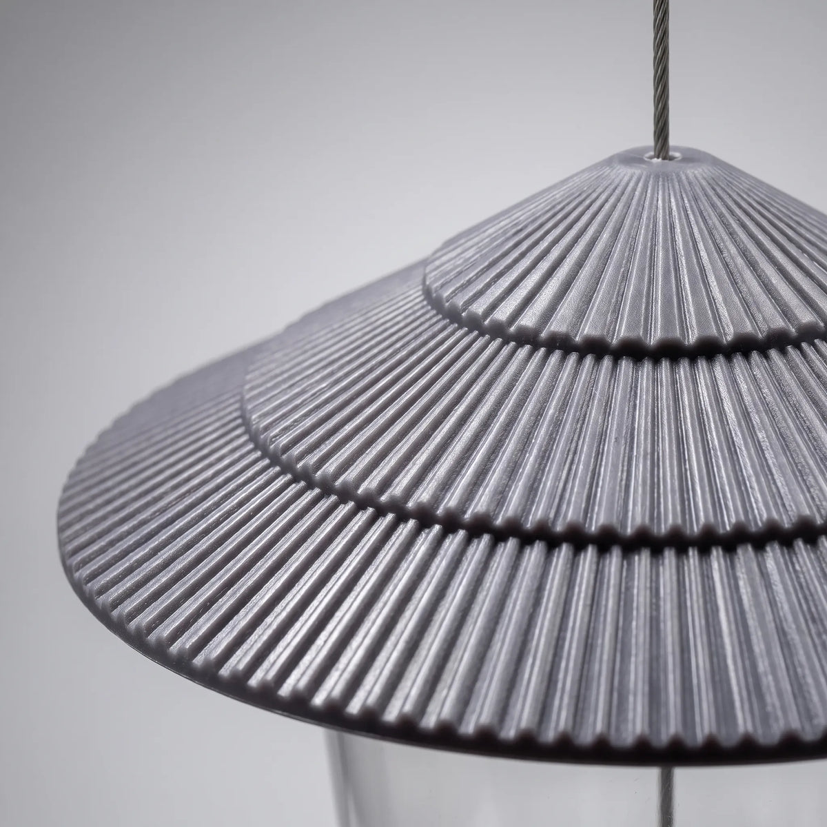 Close-up of the grey tiered, ridged roof with the steel hanging wire passing through its top. 3