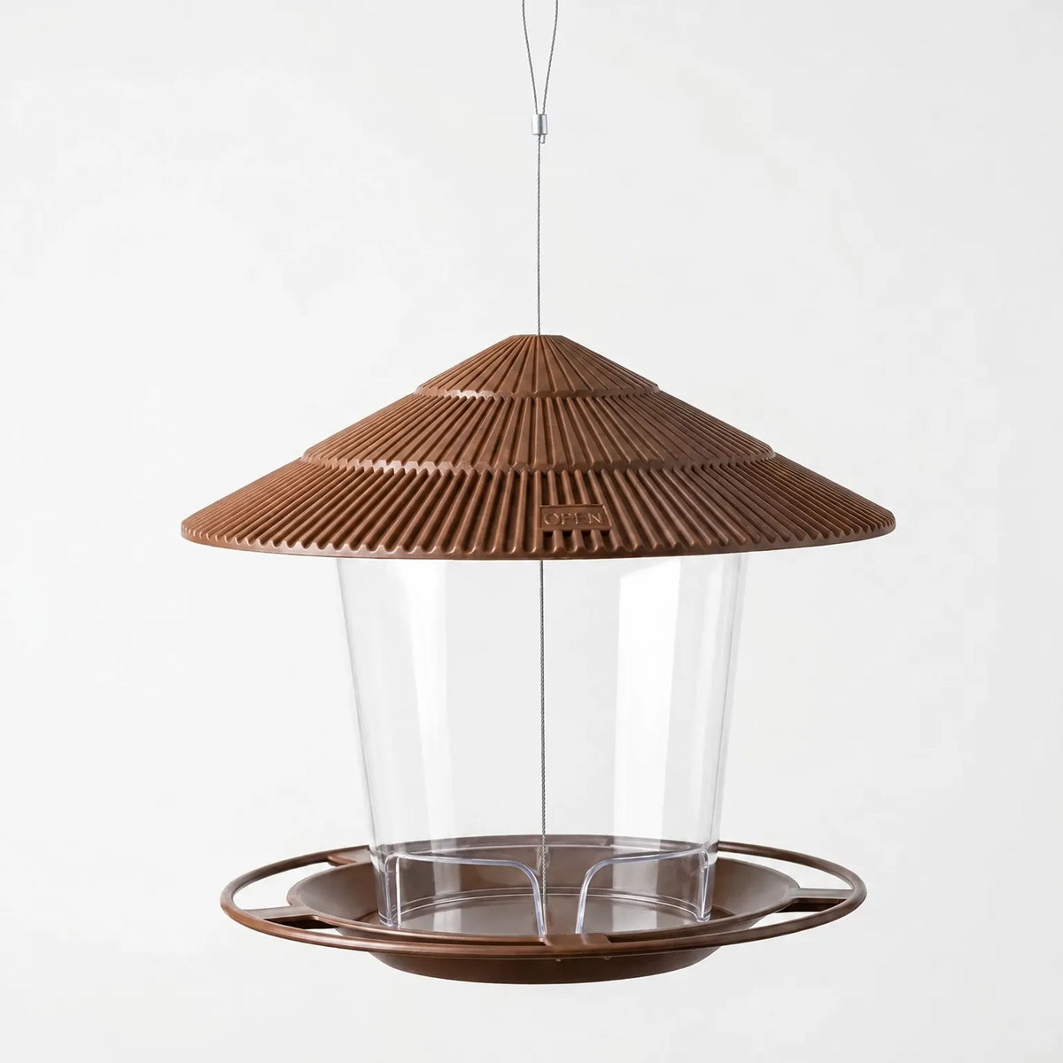 Brown feeder with clear seed container and wide round tray, shown empty against a plain pale background. 4