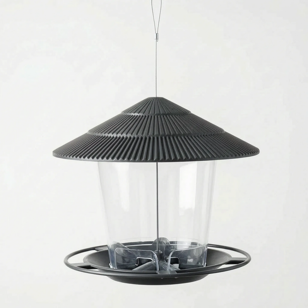Dark grey feeder shown empty, with the clear container, ridged roof and round perch ring visible from a slightly higher angle. 5
