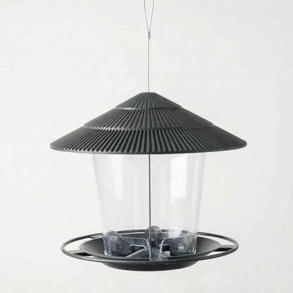 Dark grey feeder shown empty, with the clear container, ridged roof and round perch ring visible from a slightly higher angle. 5