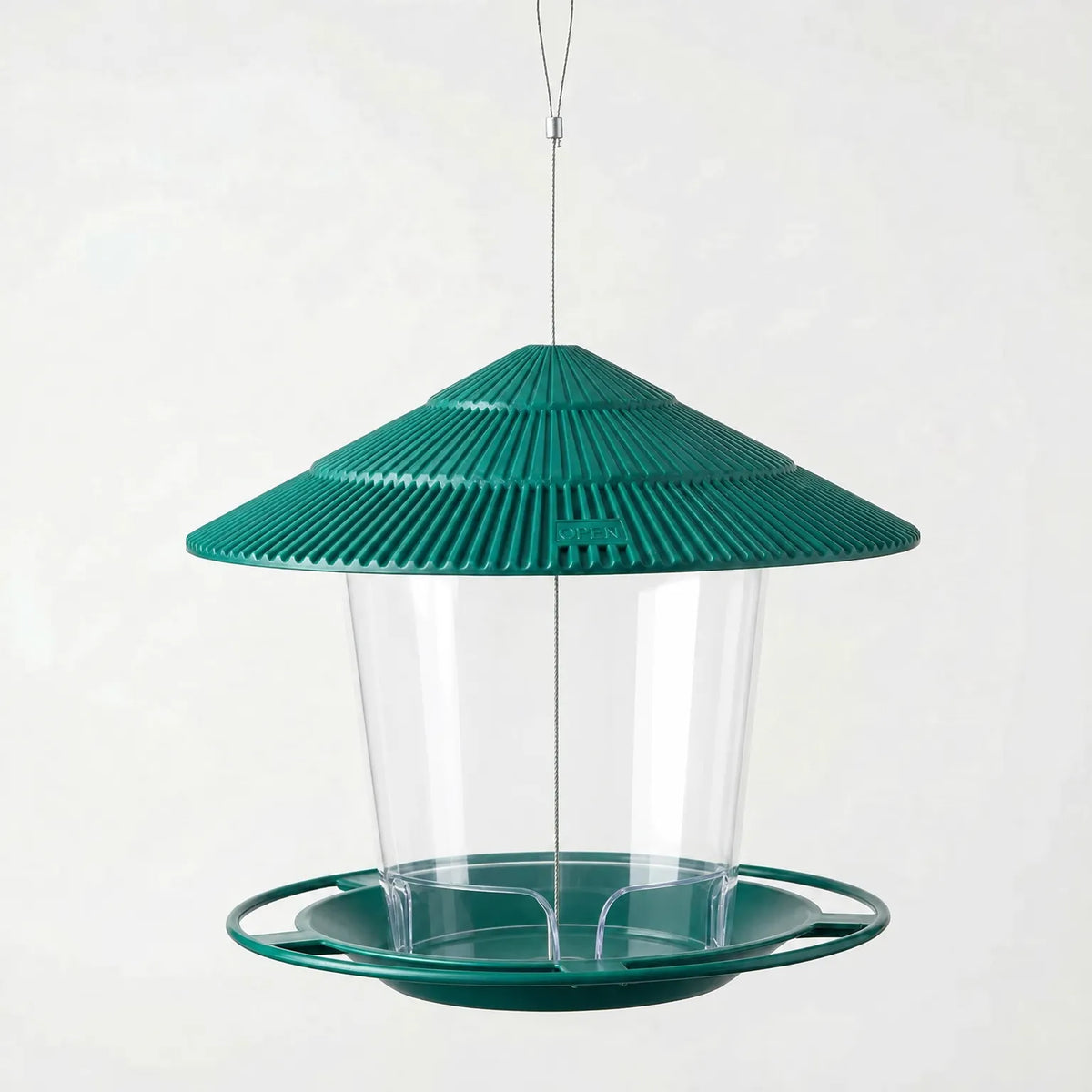 Green feeder shown empty, with ridged roof, clear seed container and round perch tray on a plain background. 6