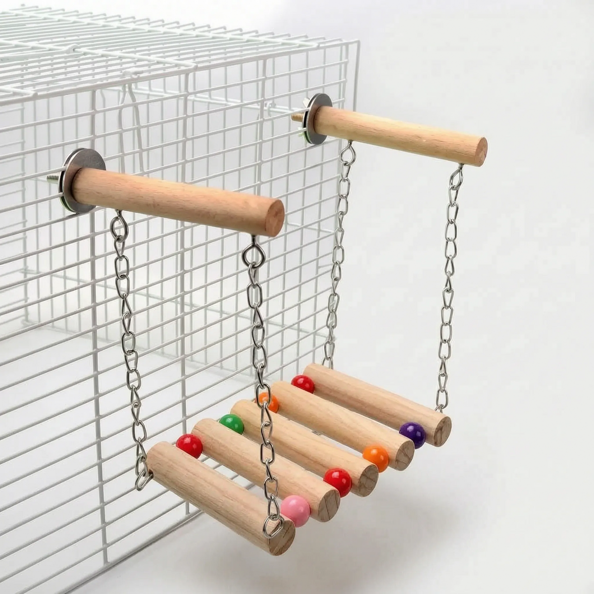 Rung bridge with coloured beads at the end of each rung, hung by chains from two wooden perches on a white cage. 4