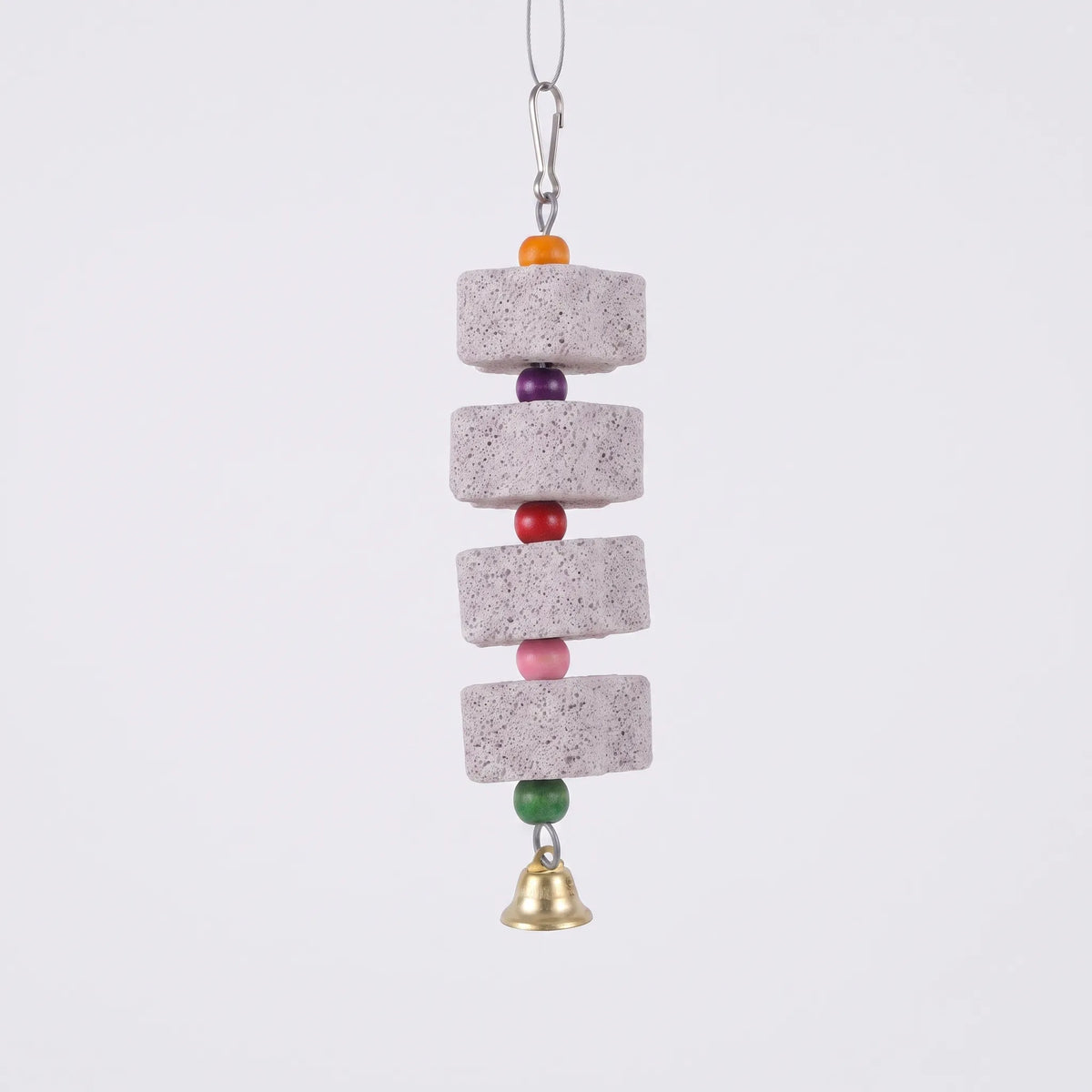 Four grey pumice blocks strung with orange, purple, red, pink and green wooden beads, a brass bell and a snap hook, on plain white. 1